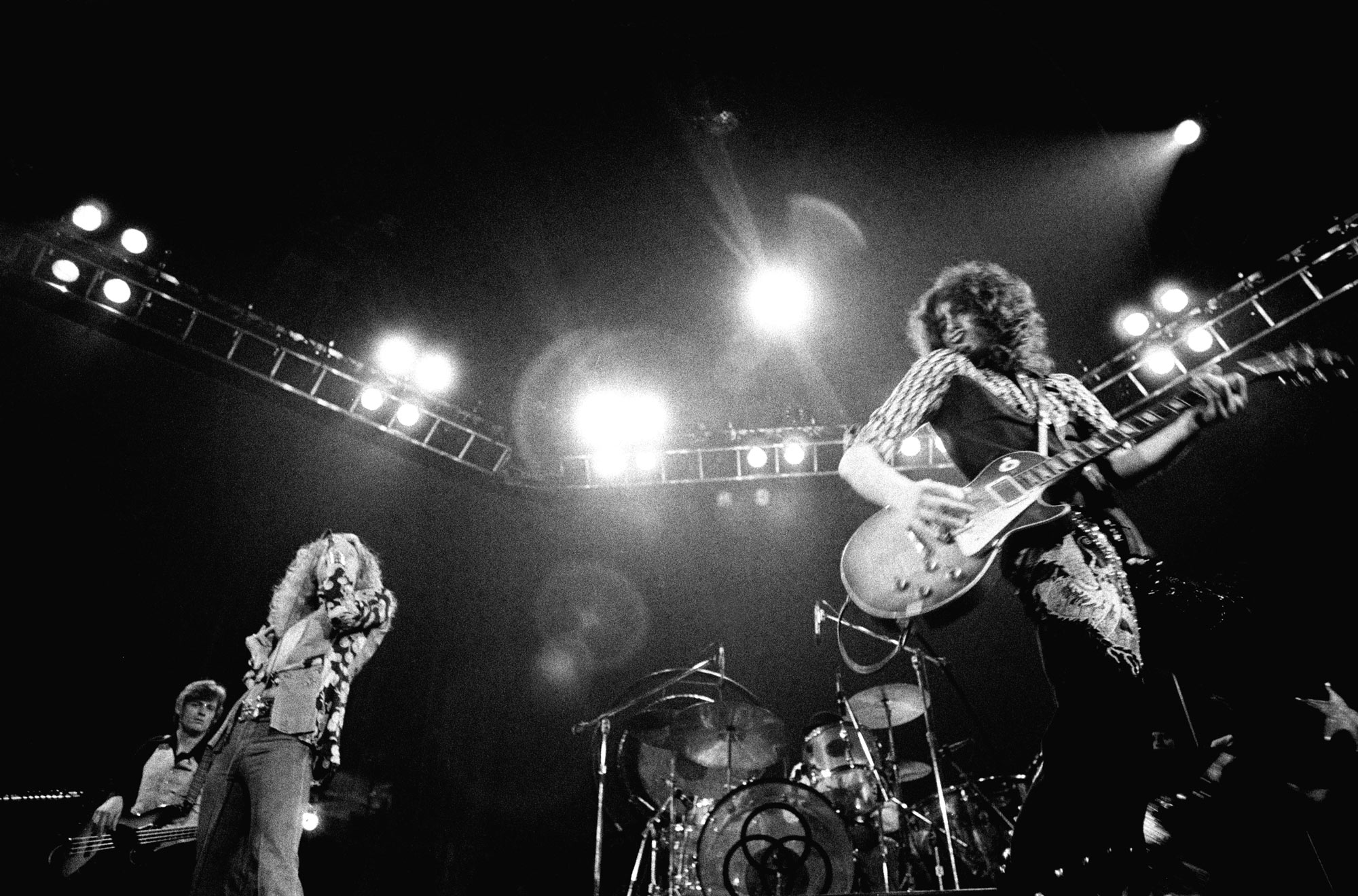 123 ROCK | Led Zeppelin | Robert Plant (Robert Anthony Plant) - August 20, 1948 - West Bromwich, Staffordshire, England, United Kingdom - Lead Vocals, Backing Vocals, Acoustic Guitar, Bass Guitar, Tambourine, Harmonica (1968 - 1980) (1994) (1998), Jimmy Page (James Patrick Page) - January 9, 1944 - Heston, Middlesex, London, England, United Kingdom - Electric Guitars, Rhythm Guitar, Acoustic Guitar, Twelve-string Guitar, Pedal Steel Guitars, Lap Steel Guitar, Slide Guitar, Double Neck Guitar with Six-String and Twelve-String, Bass Guitar, Mandolin, Theremin, Banjo, Dulcimer, The Gizmo, Backing Vocals (1968 - 1980) (1994) (1998), John Paul Jones (John Baldwin) - January 3, 1946 - Sidcup, Kent, London, England, United Kingdom - Bass Guitar, Guitar, Mandolin, Double Bass, Keyboards, Organ, Piano, Acoustic Piano, Electric Piano, Mellotron, Synthesizer, VCS3 Synthesizer, Hohner Clavinet, Hammond Organ, Harpsichord, Moog Synthesizer, Bass Guitar Effects Unit, Recorder, Backing Vocals (1968 - 1980), John Bonham (John Henry Bonham) (Also called : Bonzo, The Beast, Powerhouse) - May 31, 1948 - Redditch, Worcestershire, England, United Kingdom - Drums, Percussions, Timpani, Backing Vocals (1968 - 1980) | Genre : Hard Rock, Heavy Metal, Blues Rock, Folk Rock, Progressive Rock, Psychedelic Rock | Live | Concert | Photo | 25 | Photograph