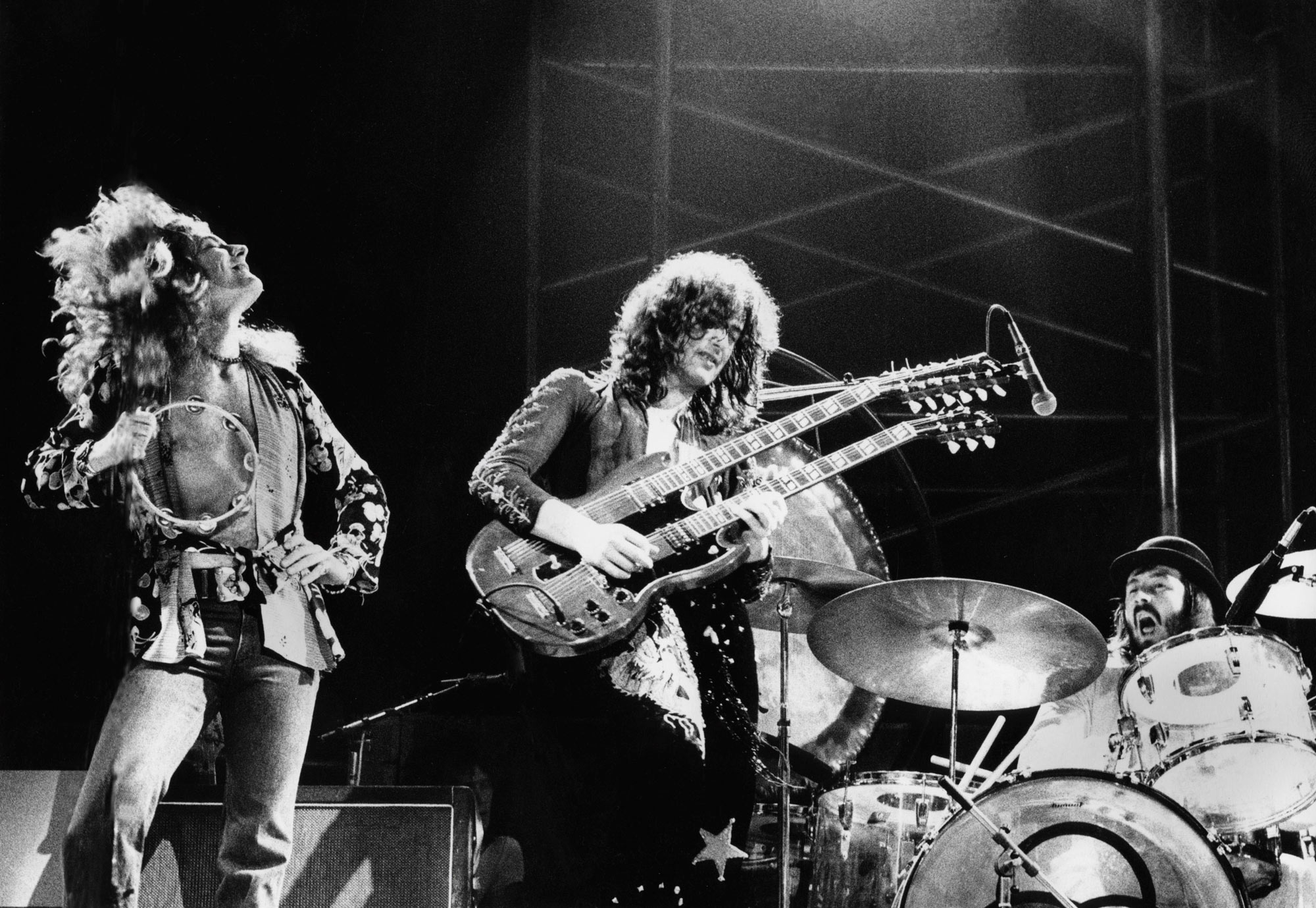 123 ROCK | Led Zeppelin | Robert Plant (Robert Anthony Plant) - August 20, 1948 - West Bromwich, Staffordshire, England, United Kingdom - Lead Vocals, Backing Vocals, Acoustic Guitar, Bass Guitar, Tambourine, Harmonica (1968 - 1980) (1994) (1998), Jimmy Page (James Patrick Page) - January 9, 1944 - Heston, Middlesex, London, England, United Kingdom - Electric Guitars, Rhythm Guitar, Acoustic Guitar, Twelve-string Guitar, Pedal Steel Guitars, Lap Steel Guitar, Slide Guitar, Double Neck Guitar with Six-String and Twelve-String, Bass Guitar, Mandolin, Theremin, Banjo, Dulcimer, The Gizmo, Backing Vocals (1968 - 1980) (1994) (1998), John Paul Jones (John Baldwin) - January 3, 1946 - Sidcup, Kent, London, England, United Kingdom - Bass Guitar, Guitar, Mandolin, Double Bass, Keyboards, Organ, Piano, Acoustic Piano, Electric Piano, Mellotron, Synthesizer, VCS3 Synthesizer, Hohner Clavinet, Hammond Organ, Harpsichord, Moog Synthesizer, Bass Guitar Effects Unit, Recorder, Backing Vocals (1968 - 1980), John Bonham (John Henry Bonham) (Also called : Bonzo, The Beast, Powerhouse) - May 31, 1948 - Redditch, Worcestershire, England, United Kingdom - Drums, Percussions, Timpani, Backing Vocals (1968 - 1980) | Live - Concert - Germany - March 1973 | Genre : Hard Rock, Heavy Metal, Blues Rock, Folk Rock, Progressive Rock, Psychedelic Rock | Live | Concert | Photo | 28 | Photograph