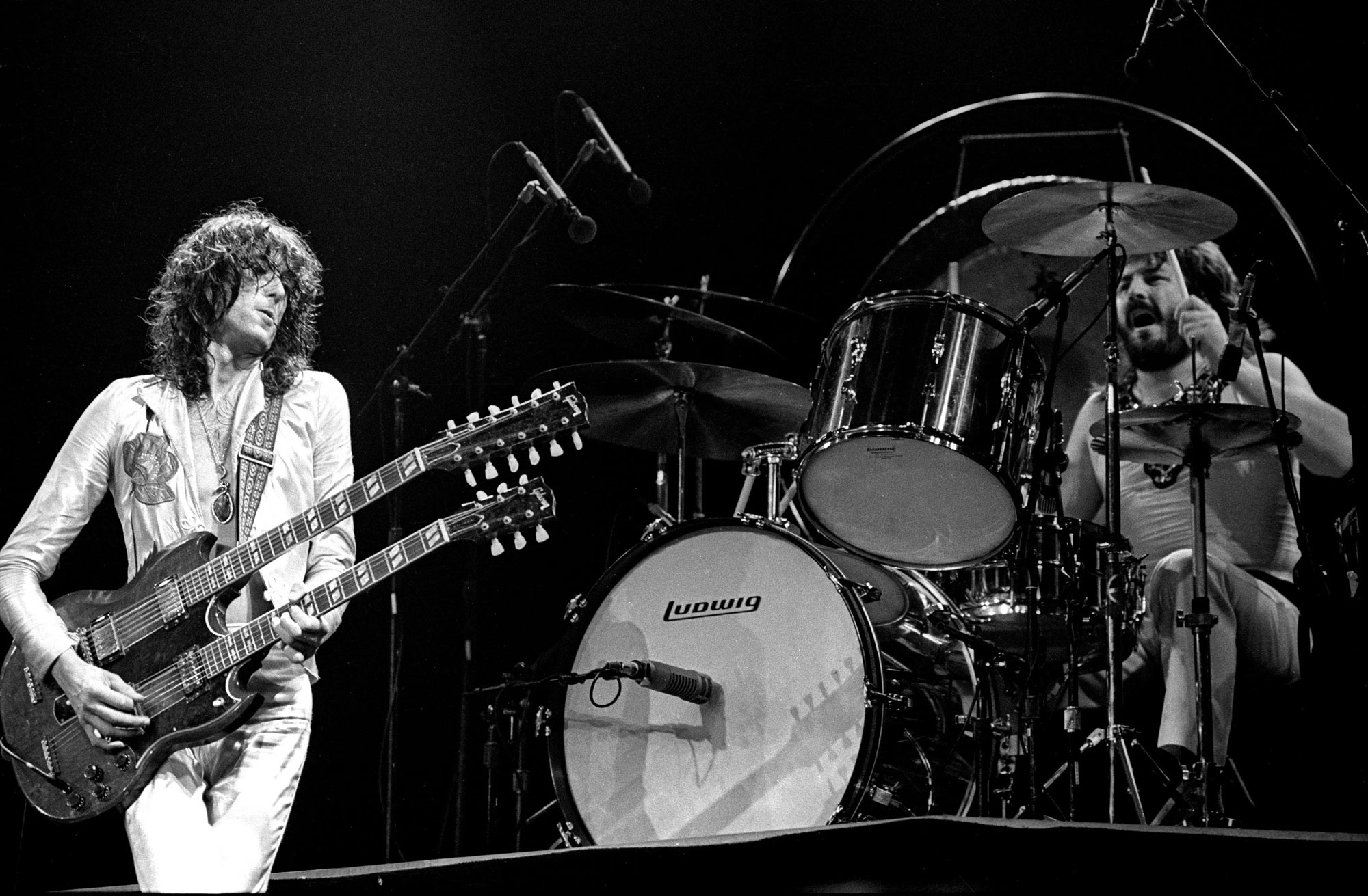 123 ROCK | Led Zeppelin | Robert Plant (Robert Anthony Plant) - August 20, 1948 - West Bromwich, Staffordshire, England, United Kingdom - Lead Vocals, Backing Vocals, Acoustic Guitar, Bass Guitar, Tambourine, Harmonica (1968 - 1980) (1994) (1998), Jimmy Page (James Patrick Page) - January 9, 1944 - Heston, Middlesex, London, England, United Kingdom - Electric Guitars, Rhythm Guitar, Acoustic Guitar, Twelve-string Guitar, Pedal Steel Guitars, Lap Steel Guitar, Slide Guitar, Double Neck Guitar with Six-String and Twelve-String, Bass Guitar, Mandolin, Theremin, Banjo, Dulcimer, The Gizmo, Backing Vocals (1968 - 1980) (1994) (1998), John Paul Jones (John Baldwin) - January 3, 1946 - Sidcup, Kent, London, England, United Kingdom - Bass Guitar, Guitar, Mandolin, Double Bass, Keyboards, Organ, Piano, Acoustic Piano, Electric Piano, Mellotron, Synthesizer, VCS3 Synthesizer, Hohner Clavinet, Hammond Organ, Harpsichord, Moog Synthesizer, Bass Guitar Effects Unit, Recorder, Backing Vocals (1968 - 1980), John Bonham (John Henry Bonham) (Also called : Bonzo, The Beast, Powerhouse) - May 31, 1948 - Redditch, Worcestershire, England, United Kingdom - Drums, Percussions, Timpani, Backing Vocals (1968 - 1980) | Genre : Hard Rock, Heavy Metal, Blues Rock, Folk Rock, Progressive Rock, Psychedelic Rock | Live | Concert | Photo | 32 | Photograph