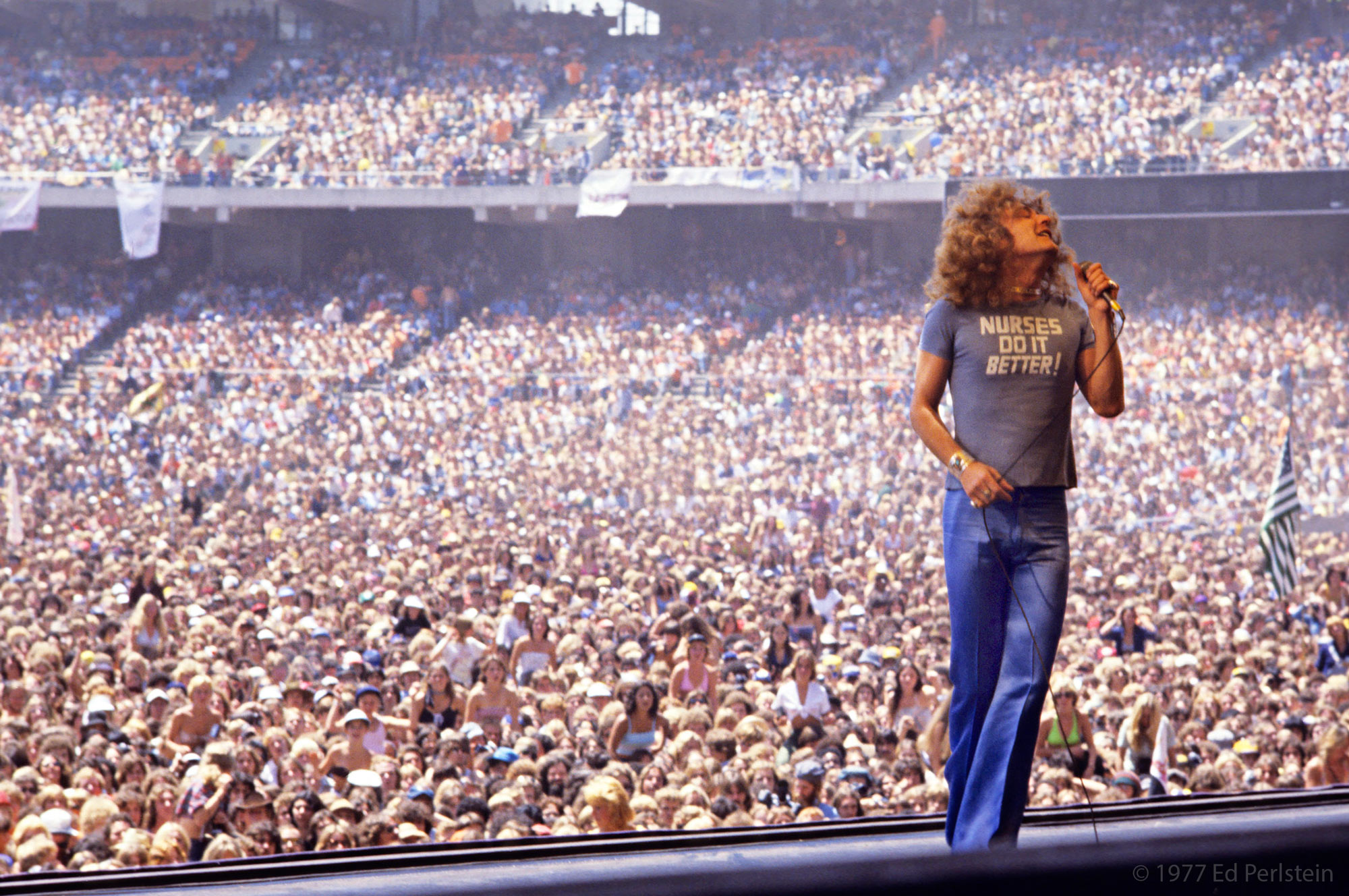 123 ROCK | Led Zeppelin | Robert Plant (Robert Anthony Plant) - August 20, 1948 - West Bromwich, Staffordshire, England, United Kingdom - Lead Vocals, Backing Vocals, Acoustic Guitar, Bass Guitar, Tambourine, Harmonica (1968 - 1980) (1994) (1998), Jimmy Page (James Patrick Page) - January 9, 1944 - Heston, Middlesex, London, England, United Kingdom - Electric Guitars, Rhythm Guitar, Acoustic Guitar, Twelve-string Guitar, Pedal Steel Guitars, Lap Steel Guitar, Slide Guitar, Double Neck Guitar with Six-String and Twelve-String, Bass Guitar, Mandolin, Theremin, Banjo, Dulcimer, The Gizmo, Backing Vocals (1968 - 1980) (1994) (1998), John Paul Jones (John Baldwin) - January 3, 1946 - Sidcup, Kent, London, England, United Kingdom - Bass Guitar, Guitar, Mandolin, Double Bass, Keyboards, Organ, Piano, Acoustic Piano, Electric Piano, Mellotron, Synthesizer, VCS3 Synthesizer, Hohner Clavinet, Hammond Organ, Harpsichord, Moog Synthesizer, Bass Guitar Effects Unit, Recorder, Backing Vocals (1968 - 1980), John Bonham (John Henry Bonham) (Also called : Bonzo, The Beast, Powerhouse) - May 31, 1948 - Redditch, Worcestershire, England, United Kingdom - Drums, Percussions, Timpani, Backing Vocals (1968 - 1980) | Live - Concert - Oakland Stadium - Oakland - California - United States of America - July 23, 1977 | Genre : Hard Rock, Heavy Metal, Blues Rock, Folk Rock, Progressive Rock, Psychedelic Rock | Live | Concert | Photo | 39 | Photograph